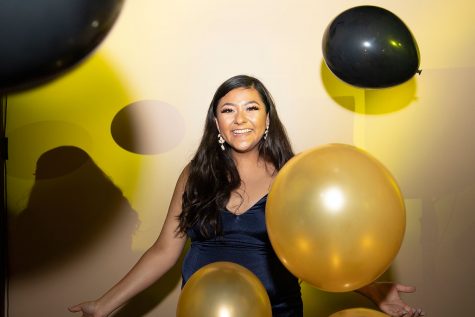 Senior Jessica Mendoza stands with the black and gold balloons around her.