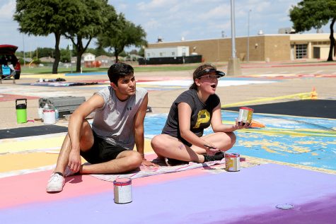 Senior Kaylee Alanis paints her parking space with friends.