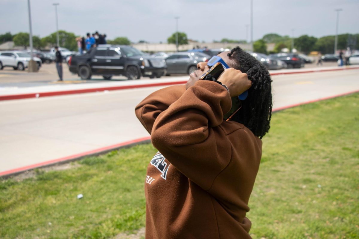 Junior Jasiah Ivery views the eclipse on April 8.