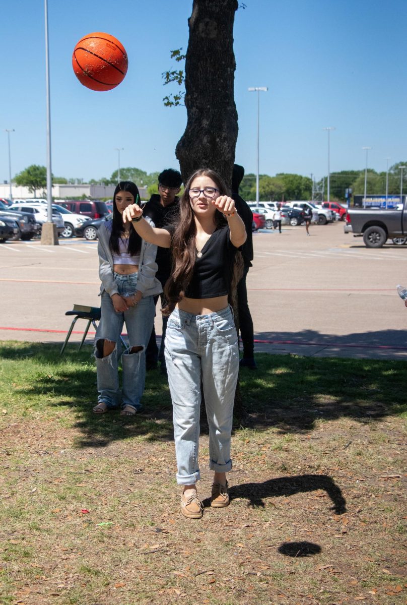 Sophomore Itzel Hernandez tosses the basketball during the English II Field Day for STAAR prep.